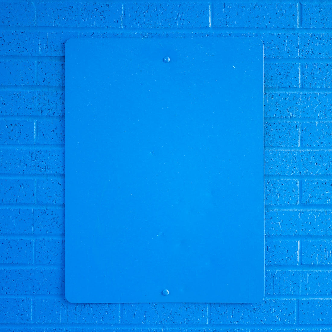 blue ipad on purple brick wall