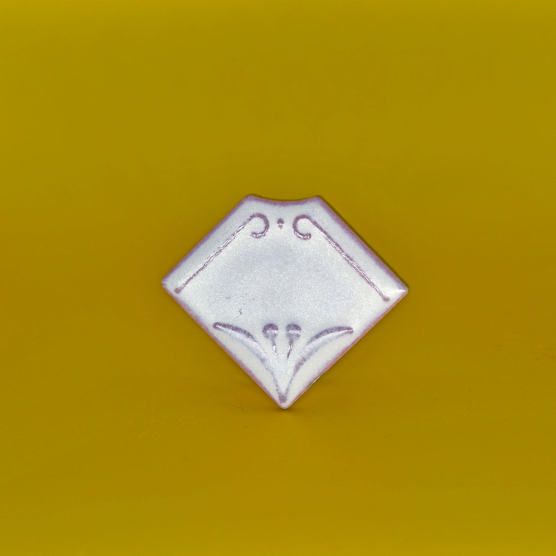 a white diamond shaped object on a yellow background