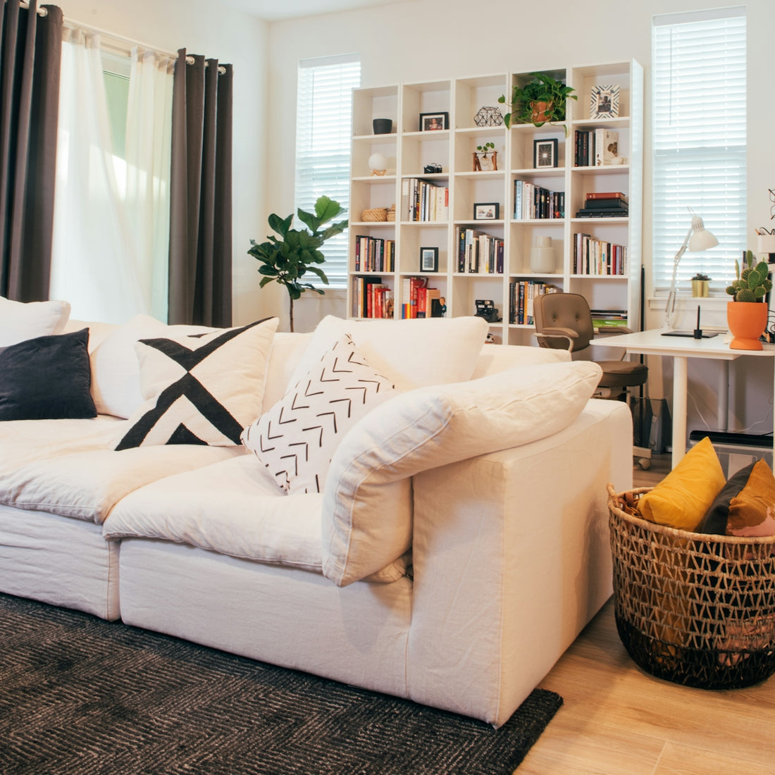 Cozy living room with large white sofa and bookshelf.