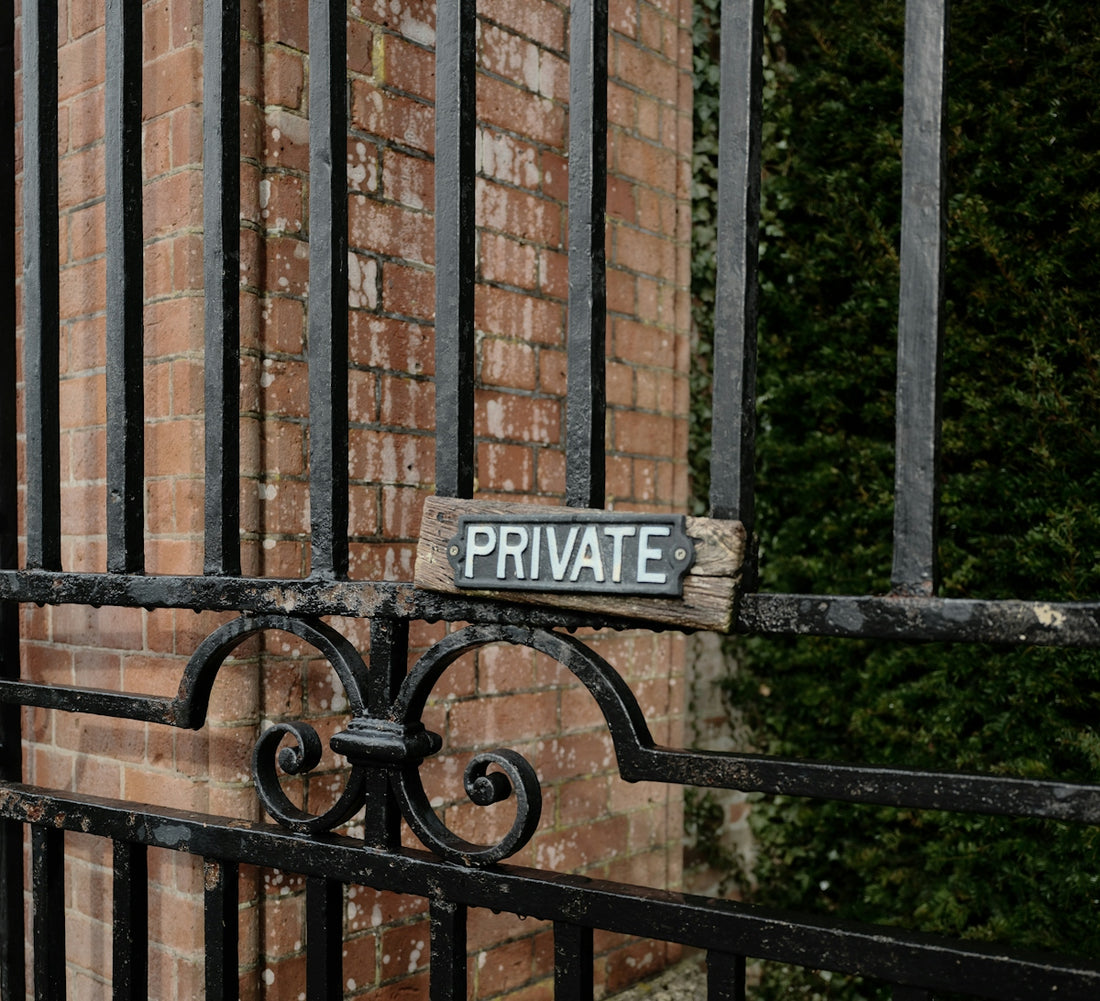 A weathered private sign on a metal gate.