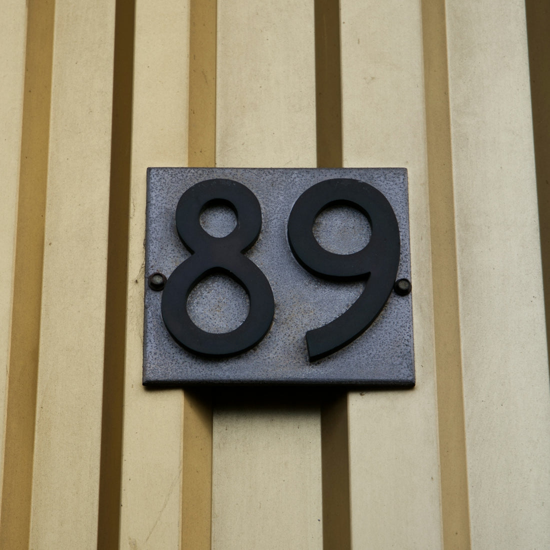 House number 89 on a textured wall