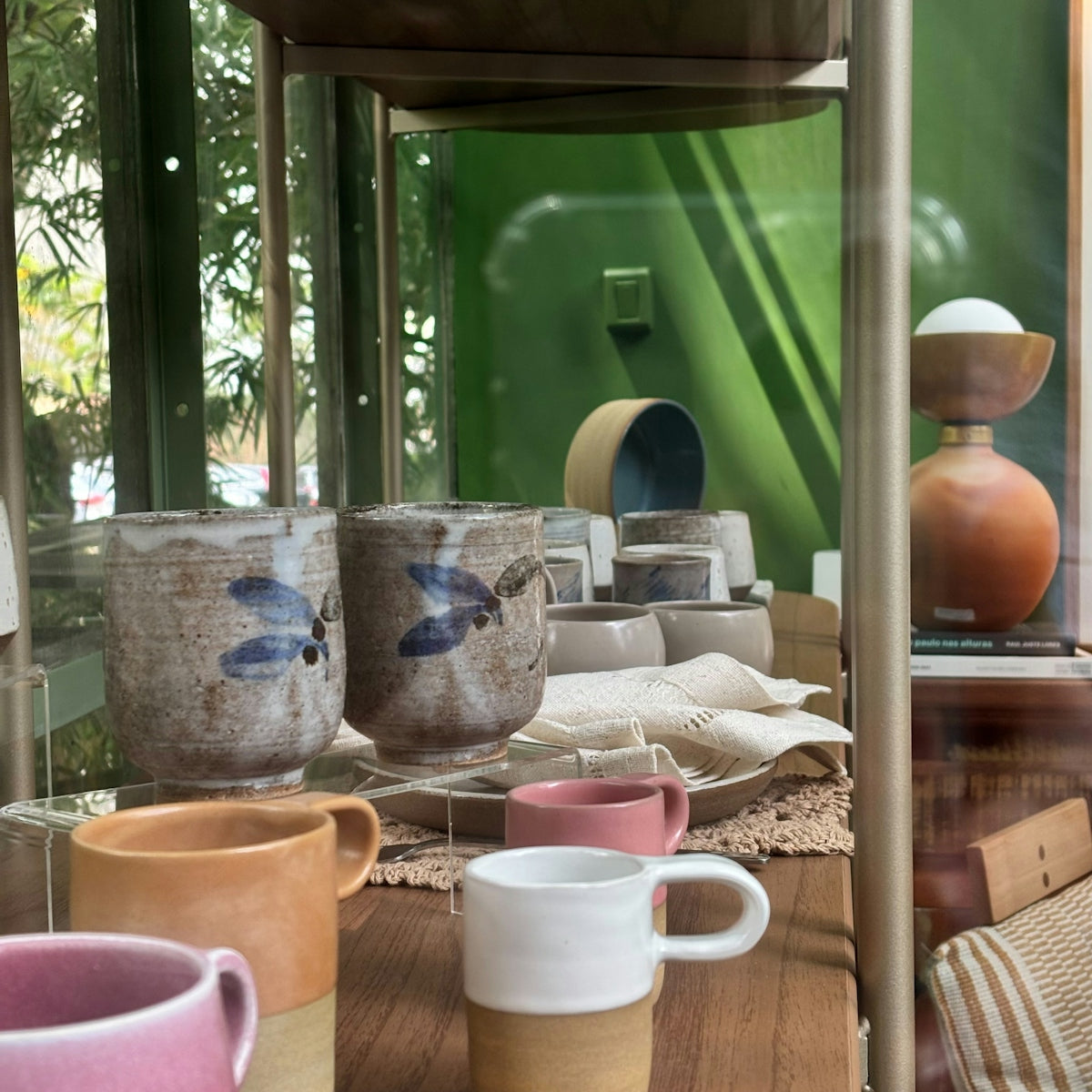 Various ceramic cups and mugs displayed on shelves.